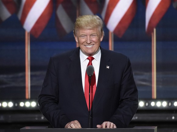 President Donald Trump smiling at podium.