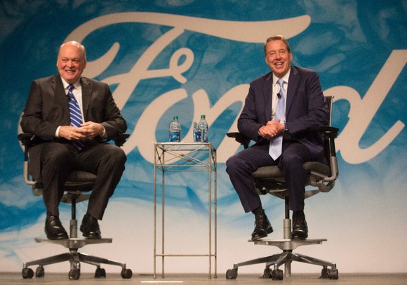 Jim Hackett and Bill Ford seated on a stage in front of the Ford logo