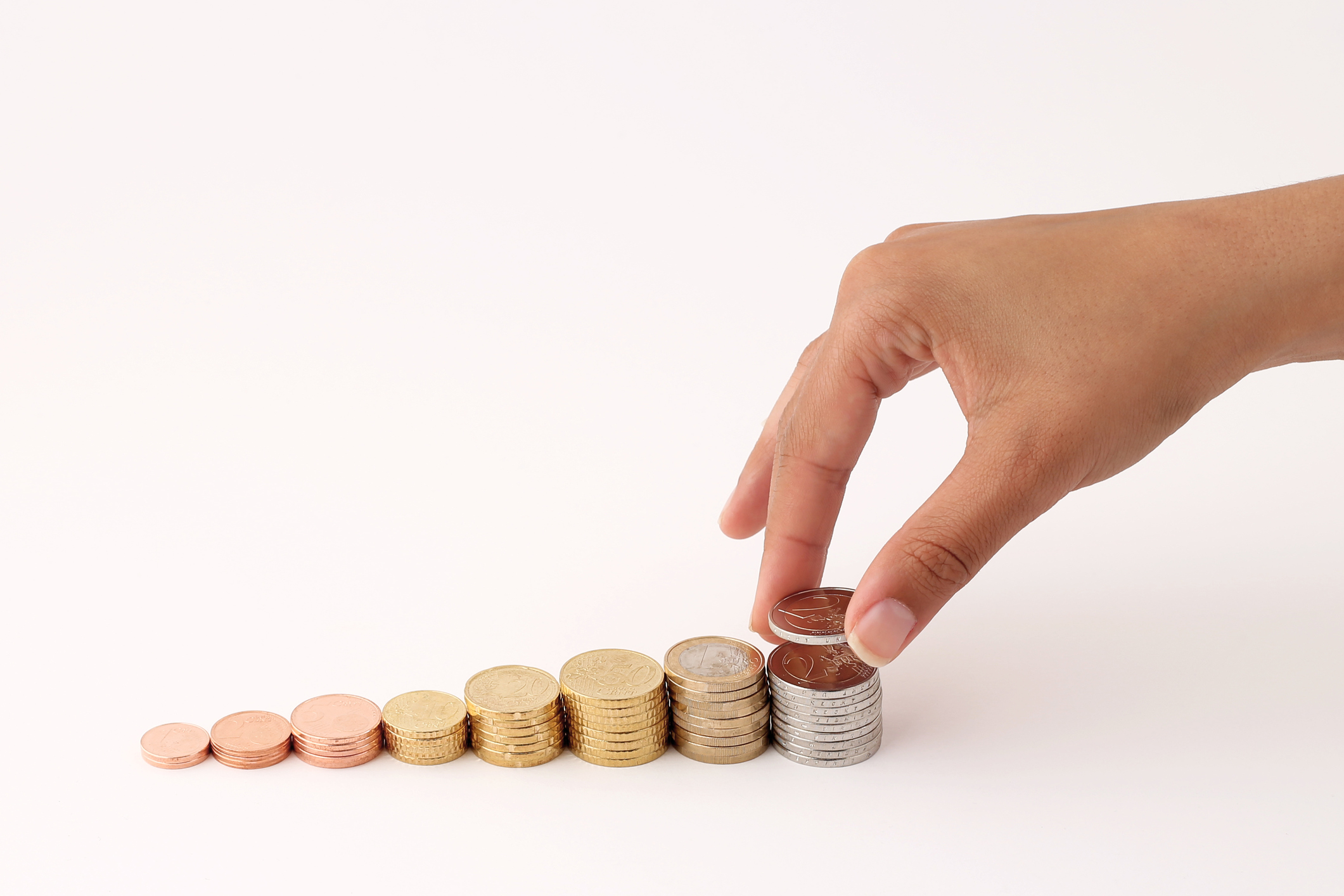 A hand stacking coins.