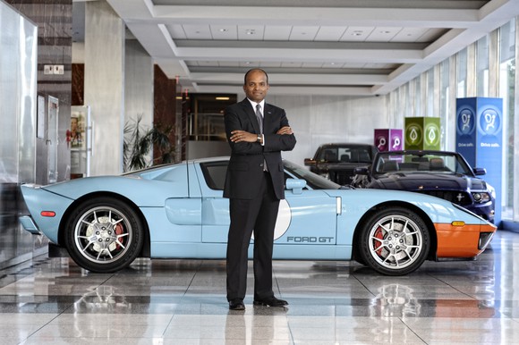 Nair is standing in front of a Ford GT sports car.