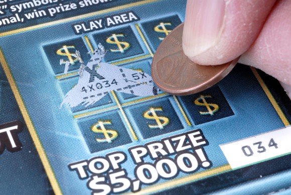 Person playing a scratch-off lottery game.