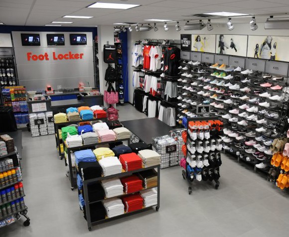 The inside of a Footlocker store with shoes and apparel on display.