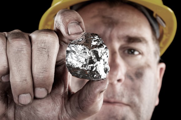 A man holding a silver rock.