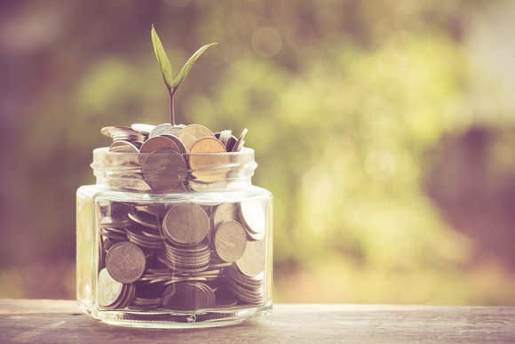 Jar of coins with a sprout growing out of it.