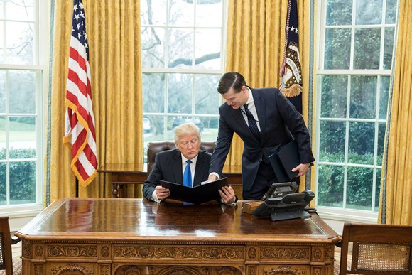 President Trump reviewing paperwork with staff.