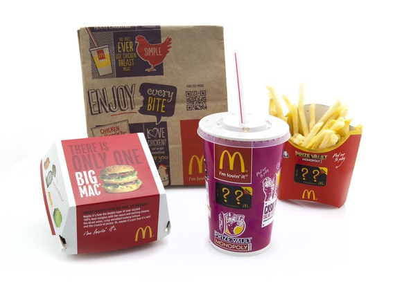 A McDonald's bag, hamburger container, fries, and soft drink.