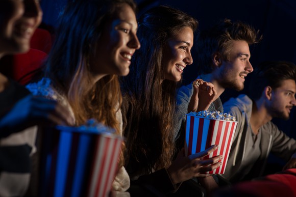 Friends watching a movie eating popcorn