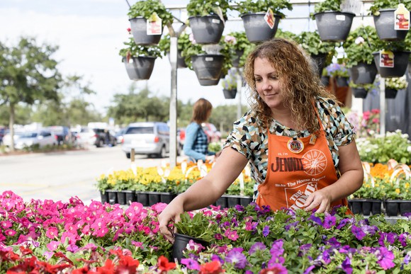 A Home Depot associate tends to a display of flowers.