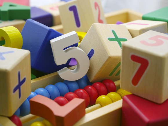 Blocks, numbers, and an abacus lie in a pile.