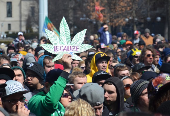 A person holds up a sign that reads "legalize" at a pro-marijuana rally.