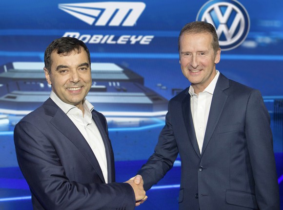 Shashua and Diess are shaking hands in front of a graphic that includes both companies' logos.