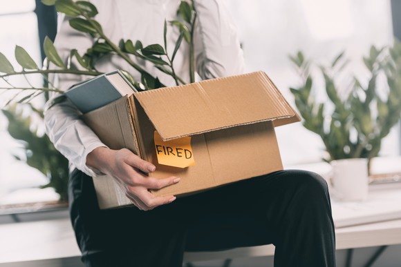 Employee carrying box with "Fired" Post-It Note