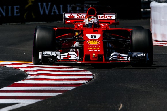 A red Ferrari Formula 1 race car rounding a corner on the race course in Monaco