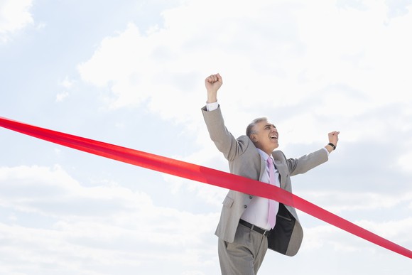 Businessman crossing finish line.