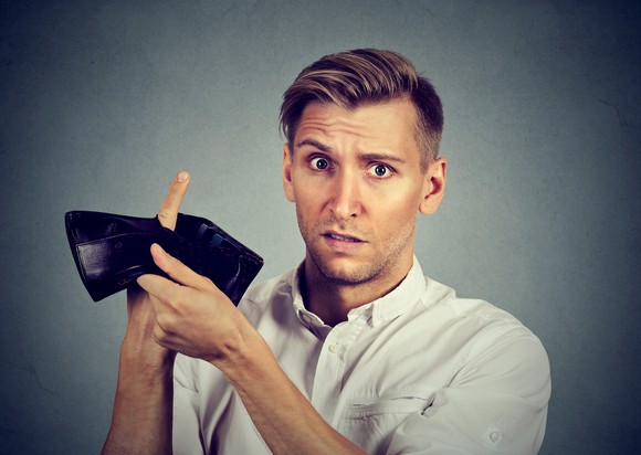 Man holding up empty wallet