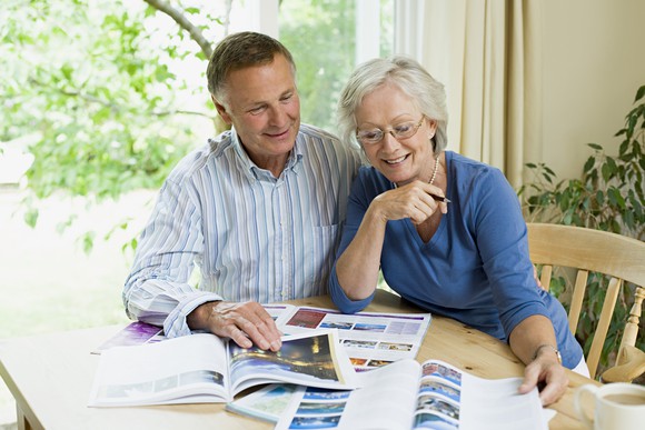 Senior couple looking at travel brochures