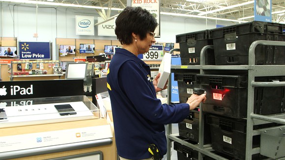 A worker prepares a digital order at Wal-Mart.