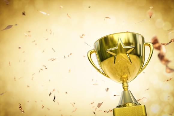 A trophy with a gold star sits against a gold background.