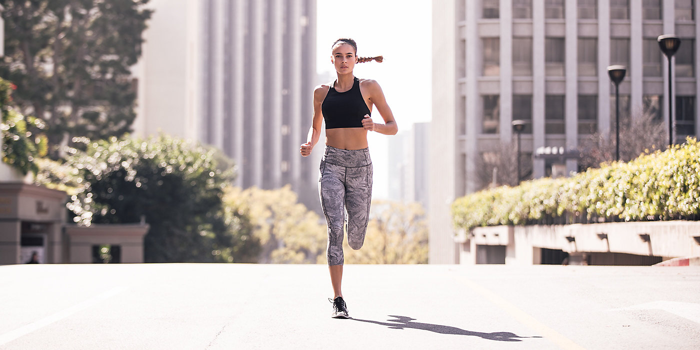 A young woman jogging in Lululemon apparel.