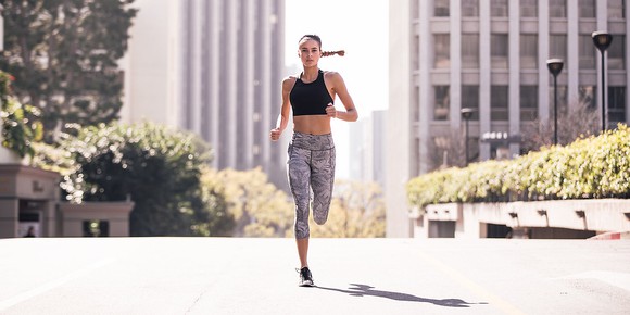 A young woman jogging in Lululemon apparel.