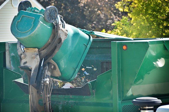 A garbage truck emptying a trash bin into its receptacle