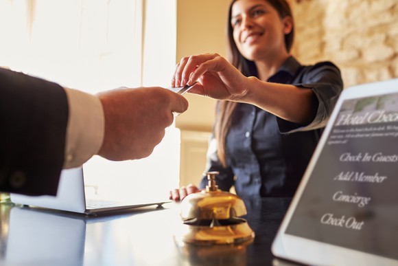 Guest getting room key from the front desk of a hotel.