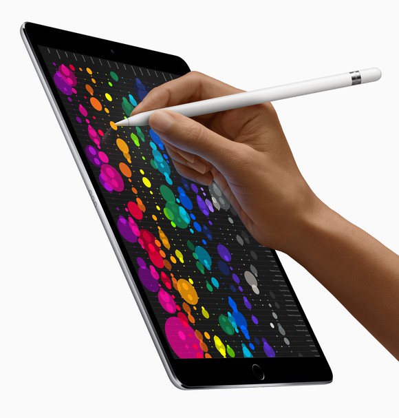 A person writes on an iPad Pro with an Apple pencil.