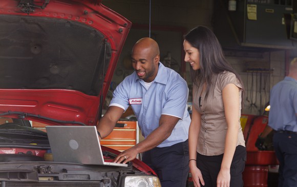Woman being helped in an automotive store.