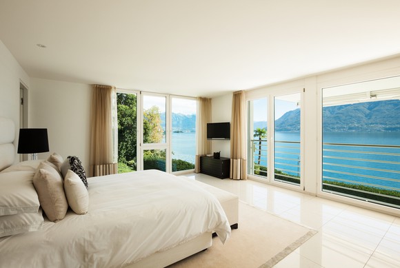 A hotel room overlooks a body of water.