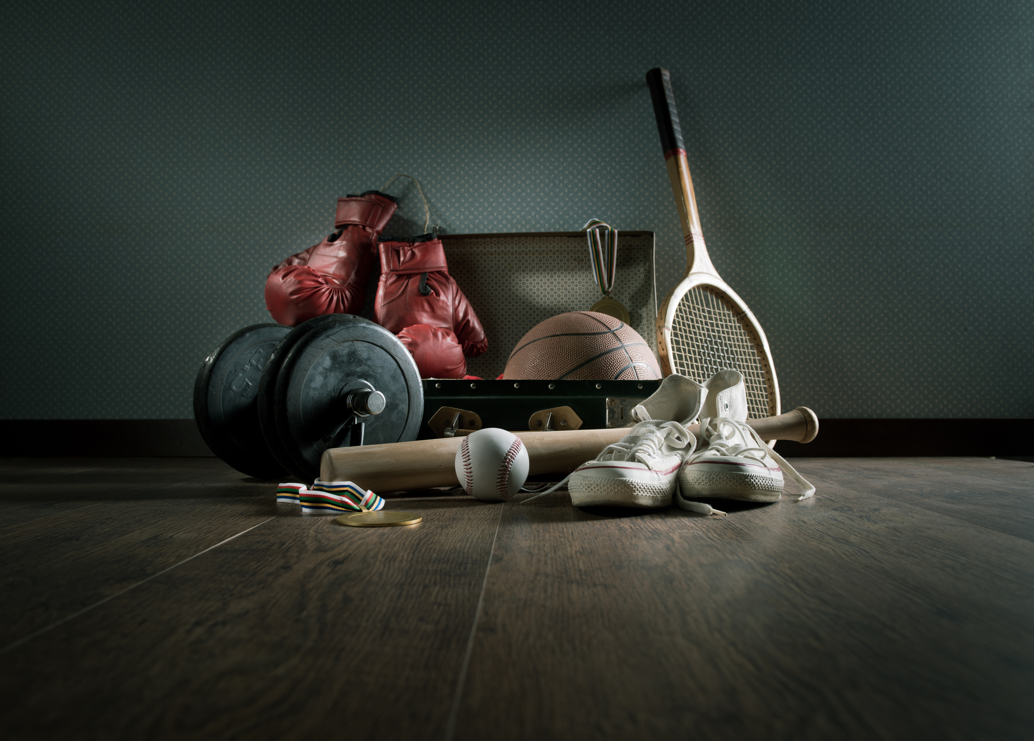 Sporting goods sitting in a pile on the floor. 