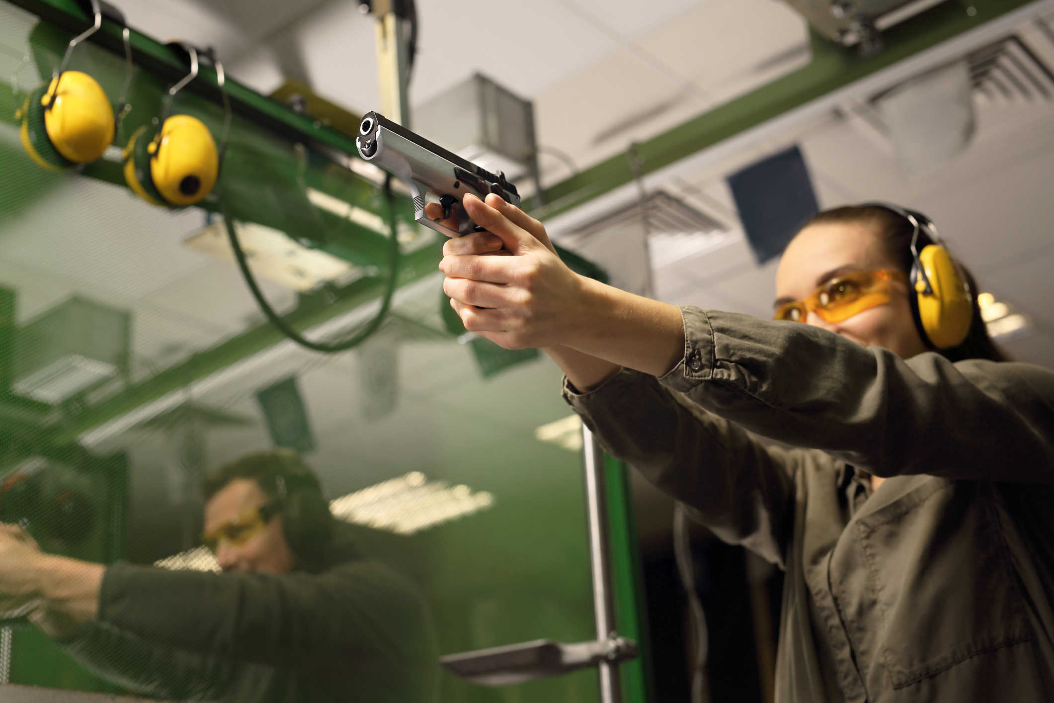 Woman shooting a handgun at a range