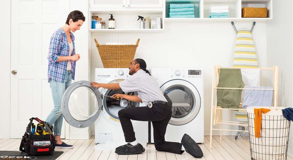 Best Buy Geek Squad employee installing washer dryer