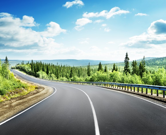 Long road stretching through forested mountains