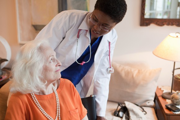A medical care provider with an elderly person in an assisted-living situation.