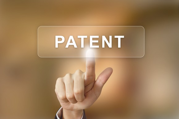 Hand pointing to patent button