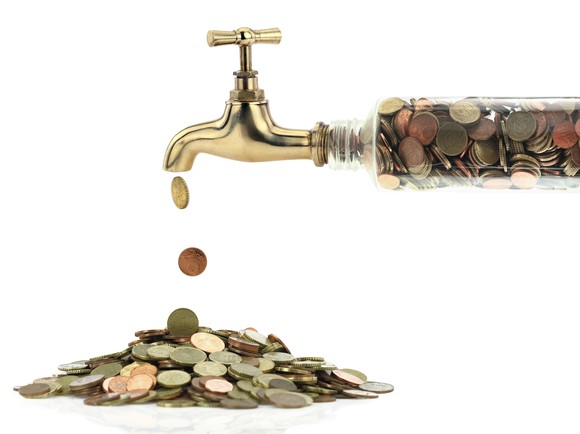 Coins dripping out of a faucet
