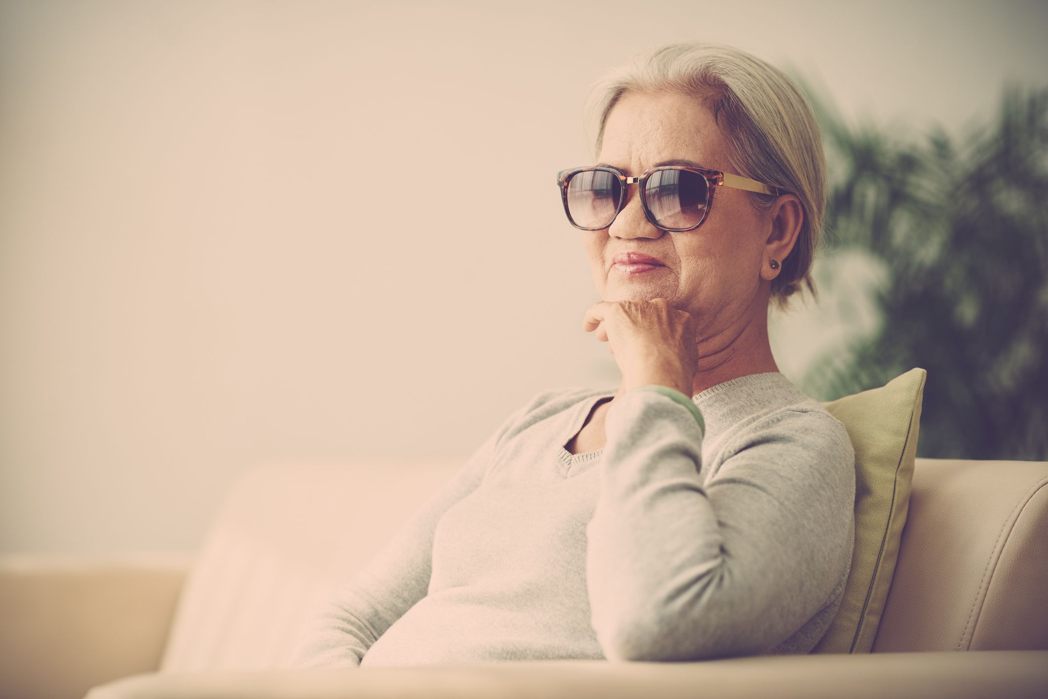 senior woman wearing sunglasses while sitting