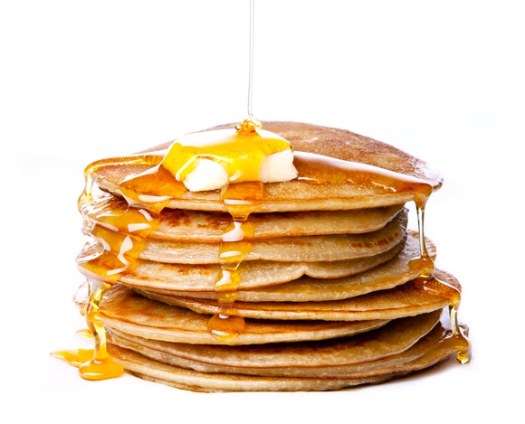 Pancakes with syrup drizzling over it.
