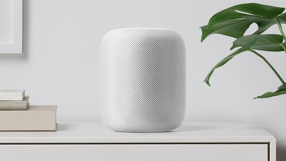 A white HomePod sitting on a shelf.