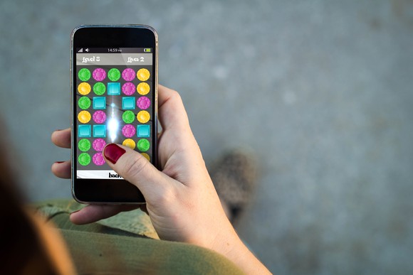 A person plays a game using one of Apple's iPhones