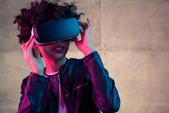 A lady wears a virtual reality headset like those made by Facebook or Sony.