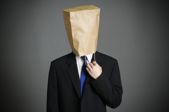 A businessman with a bag on his head.