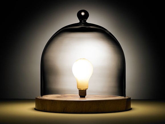 Picture of a bright light bulb under a glass dome.