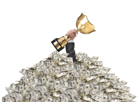 trophy held up through pile of cash