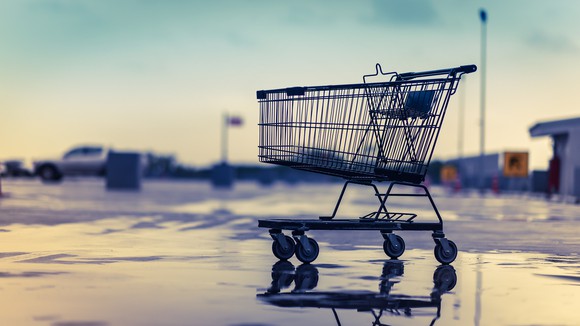 An empty shopping cart in an empty parking lot.