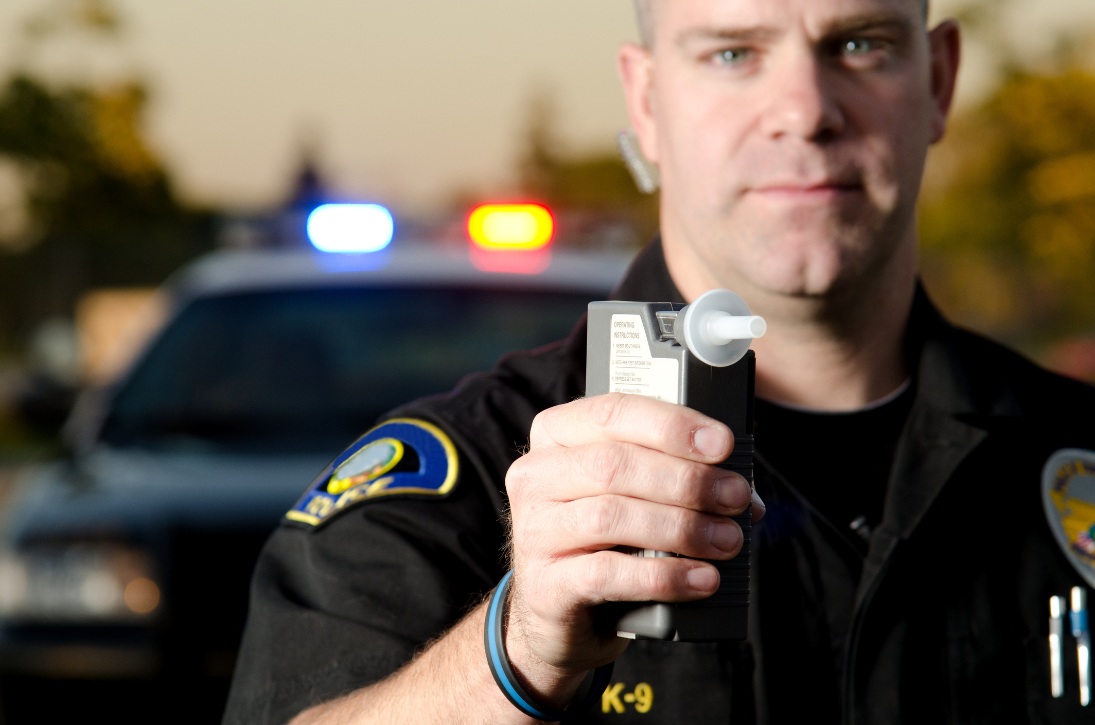 A police officer attempting to administer a breathalyzer test on a motorist.