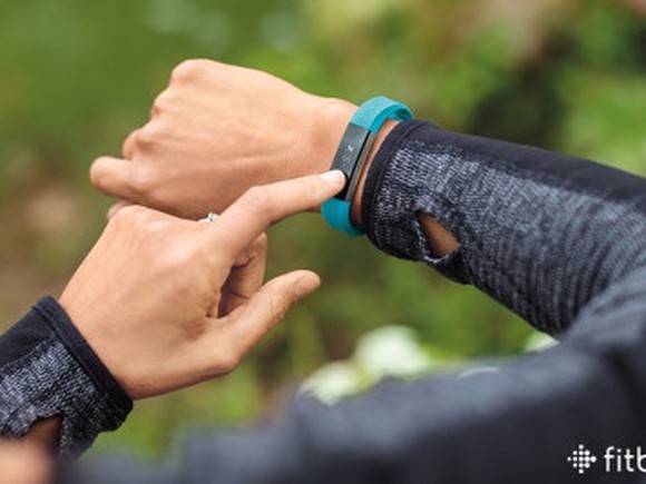 A man sets his Fitbit device.