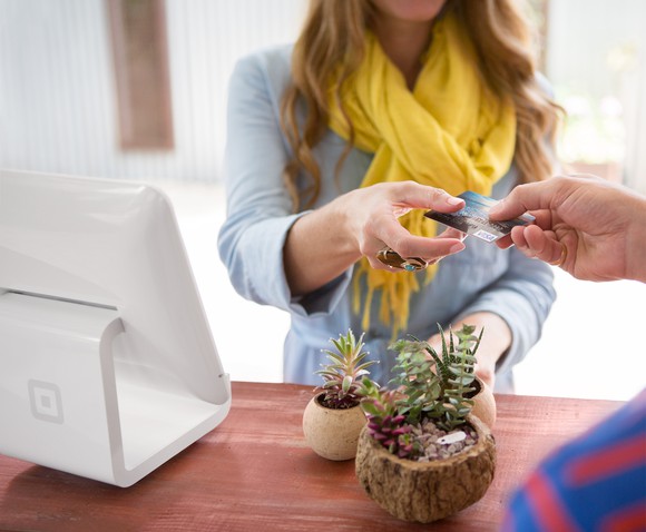 Woman using Square stand to complete a transaction