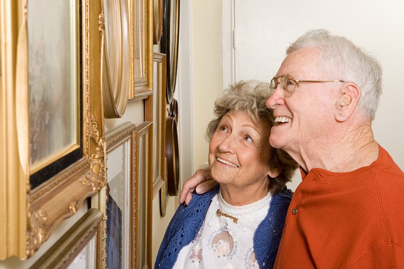 Retired couple looking at framed artwork