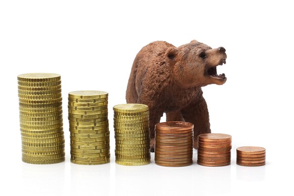 A growling bear stands behind progressively smaller stacks of coins.